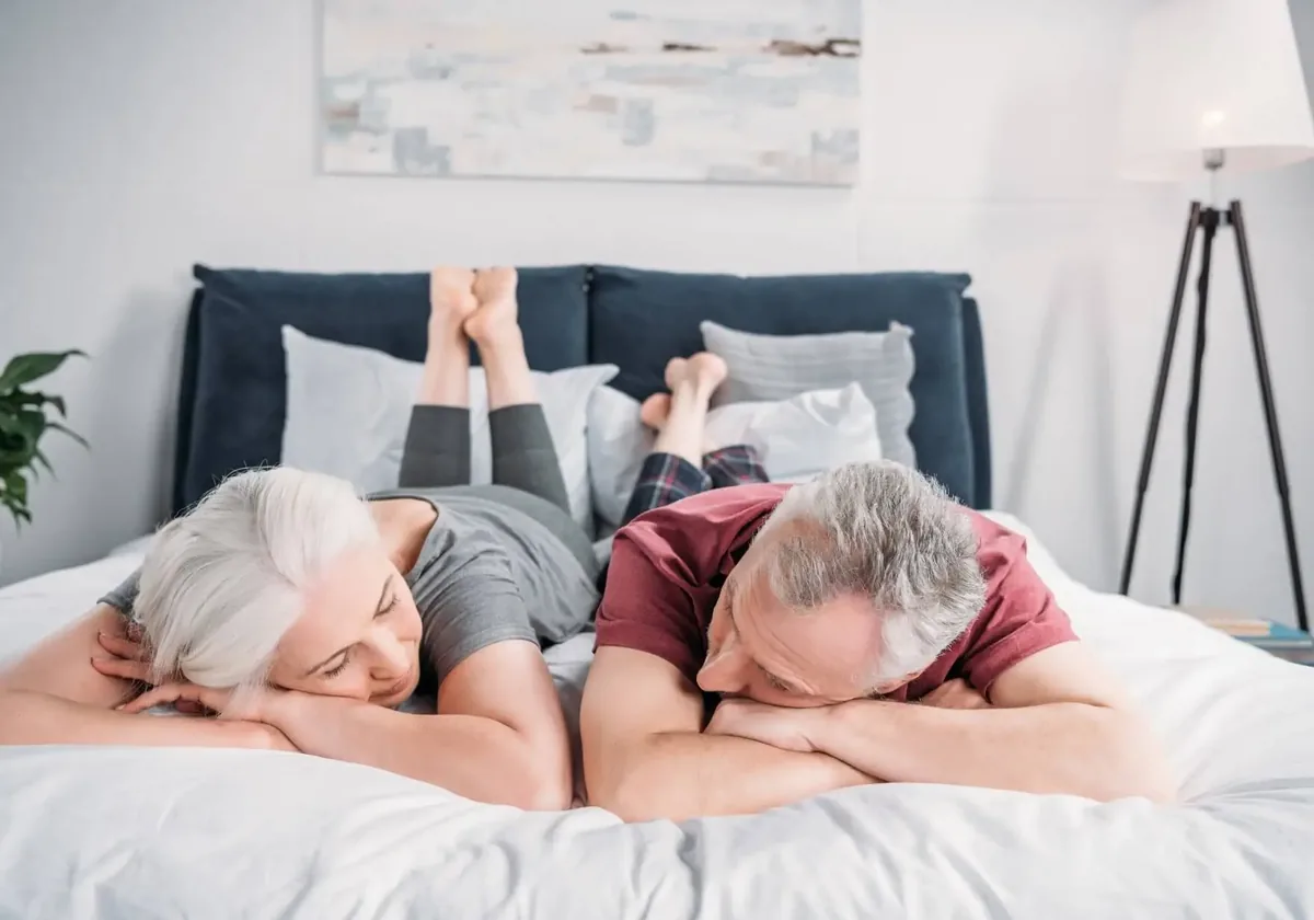 A couple resting comfortably together in bed at home
